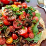 tomatoes and mushrooms piled on pizza