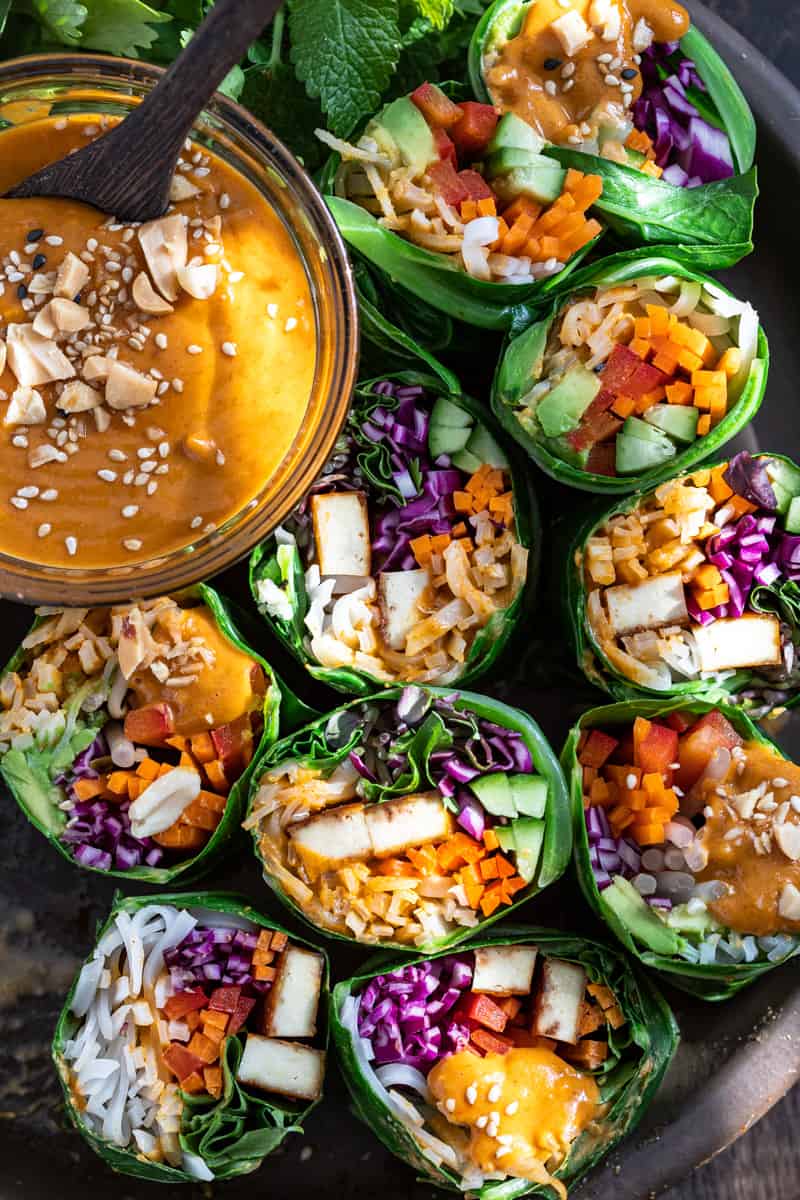 Collard Greens wraps stuffed with raw veggies and noodles with a drizzle of spicy peanut satay sauce.