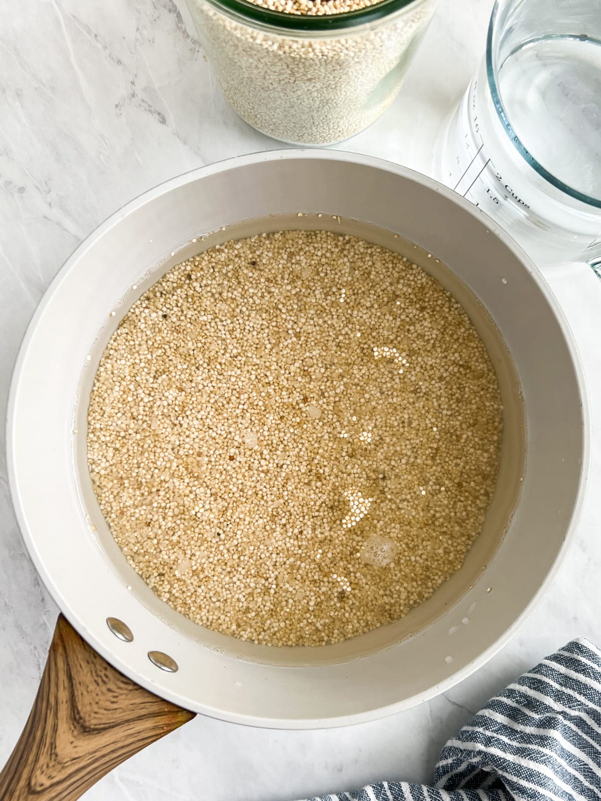 Saucepan filled with water and white quinoa.