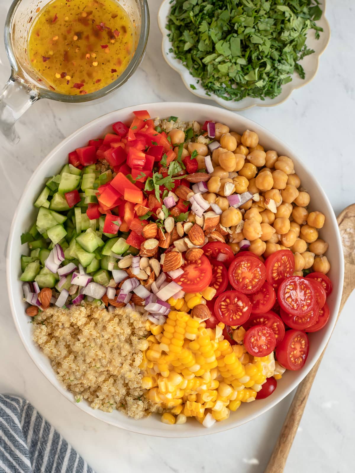 Ingredients for a veggie packed quinoa salad set out in individual bowls.