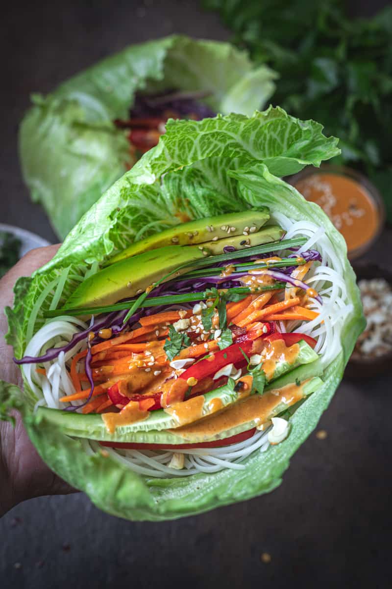 Vegetable and noodles in a lettuce cup with peanut dipping sauce.