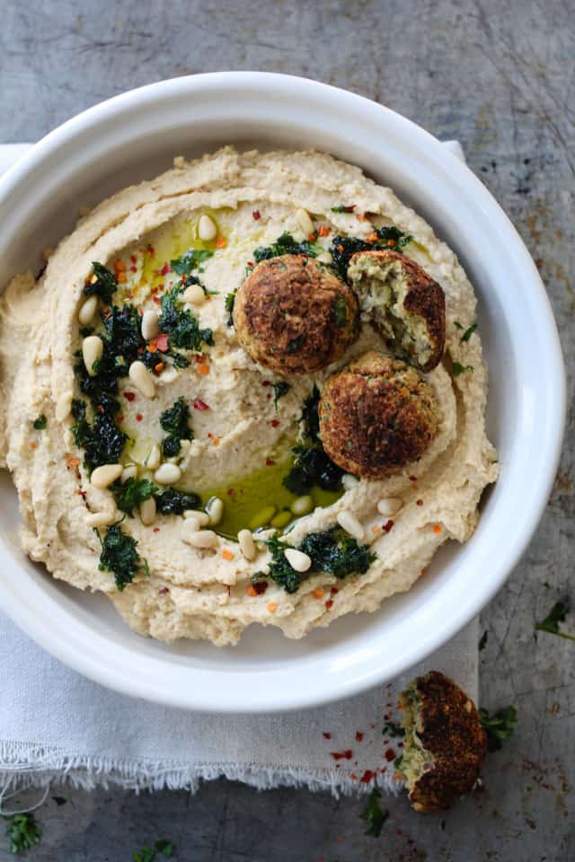 Crispy falafel balls on a big bowl of chickpea hummus.