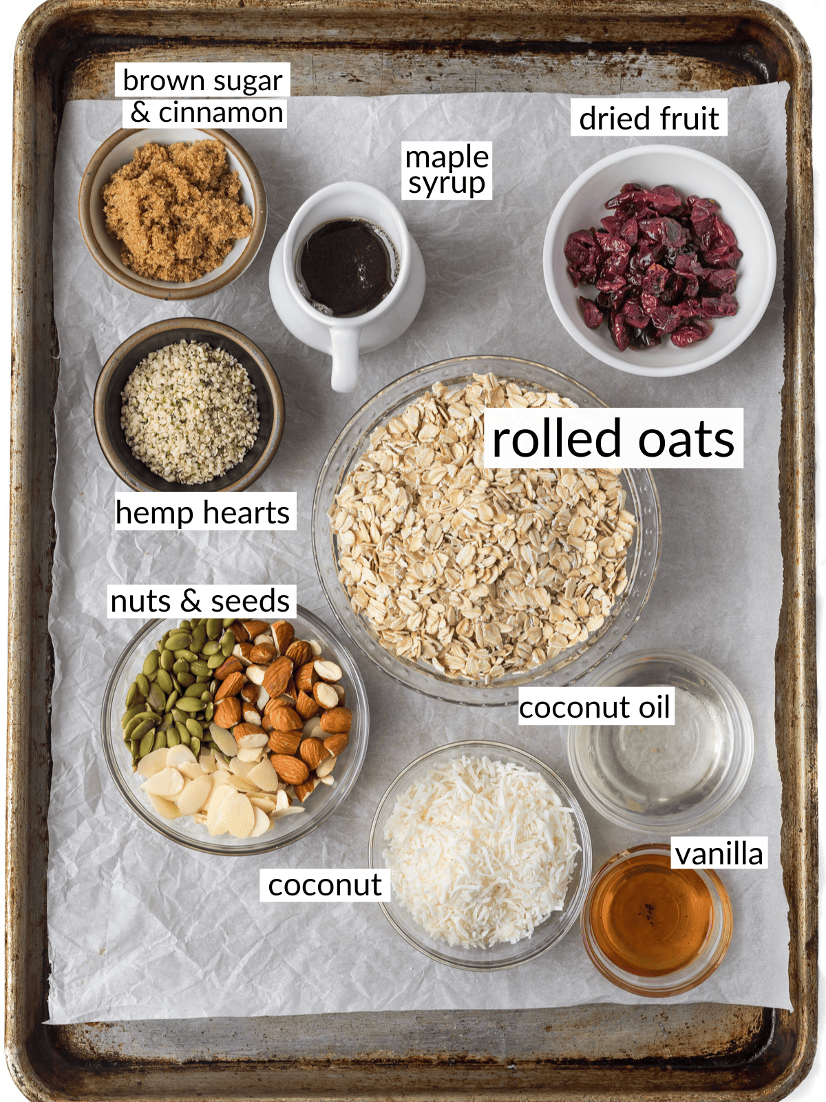 Granola ingredients measured out into bowls on a cookie sheet.
