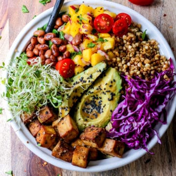 Tofu Buddha bowl with buckwheat, sprouts, beans, and avocado served in a bowl.