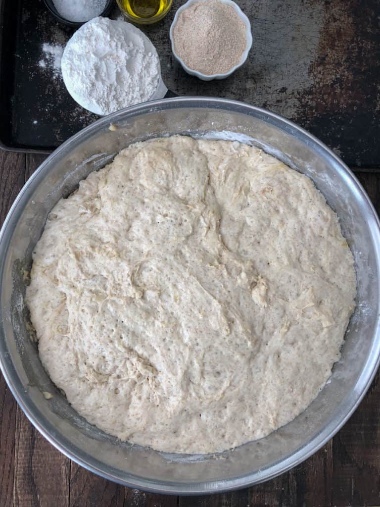 Overhead shot of bread dough proofing in a large bowl.