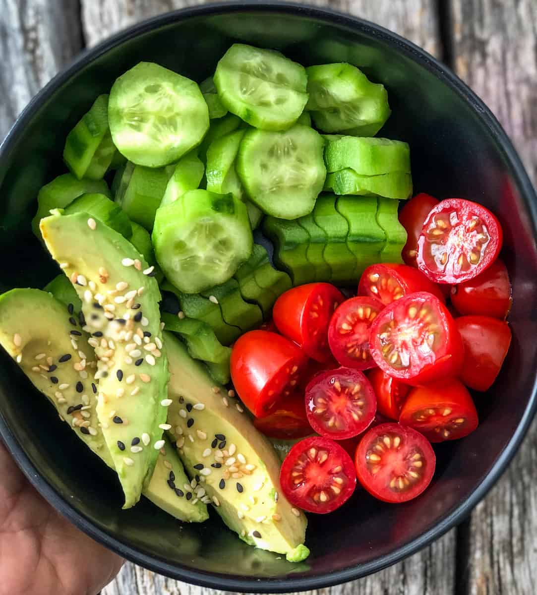 Bowl of cucumbers tomatoes and avocado slices.