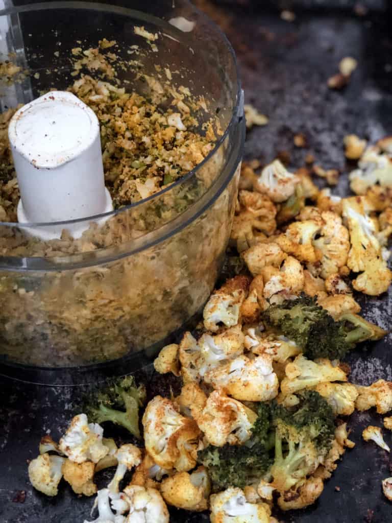 Baked cauliflower and broccoli on a baking sheet and in a food processor.