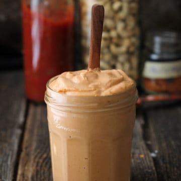 Thick cashew cream in a jar with spoon sticking up