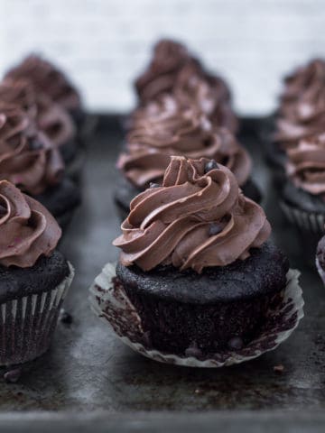 Vegan chocolate cupcakes with chocolate swirl icing on a plate.