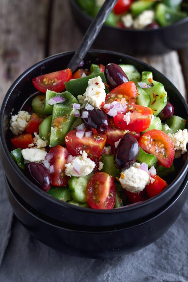 Greek salad bowl topped with vegan feta cheese.
