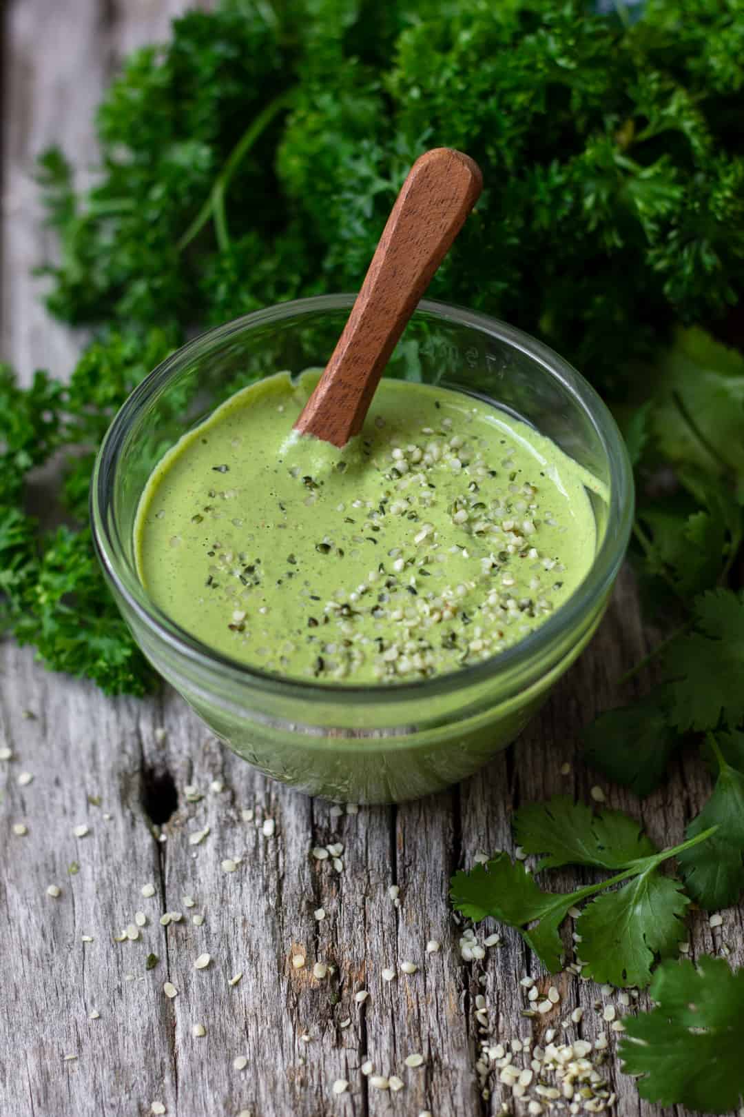 creamy cilantro sauce in bowl on wooden board