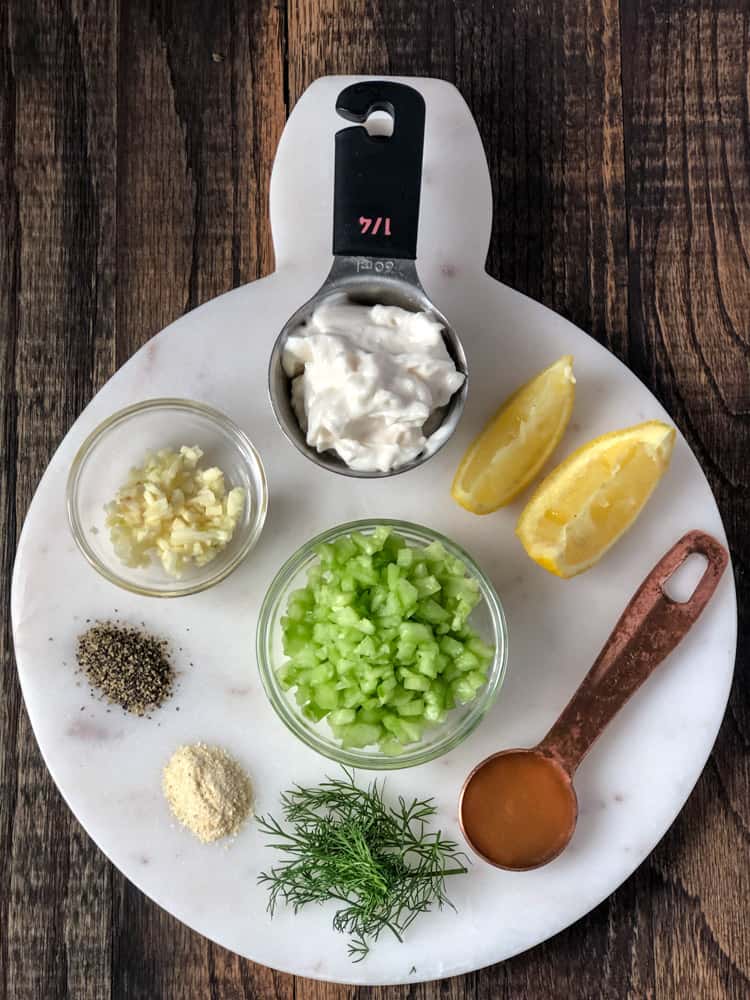 Ingredients for cucumber dill sauce in bowls on a platter.