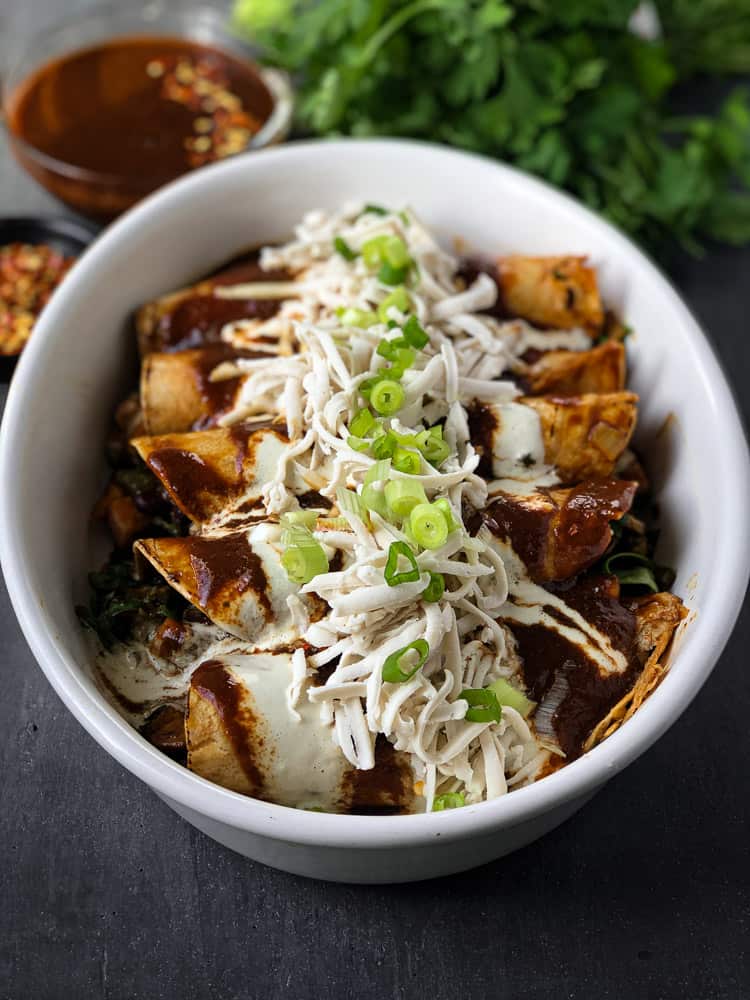 spicy mushroom enchiladas covered in sauce and cheese in a casserole dish