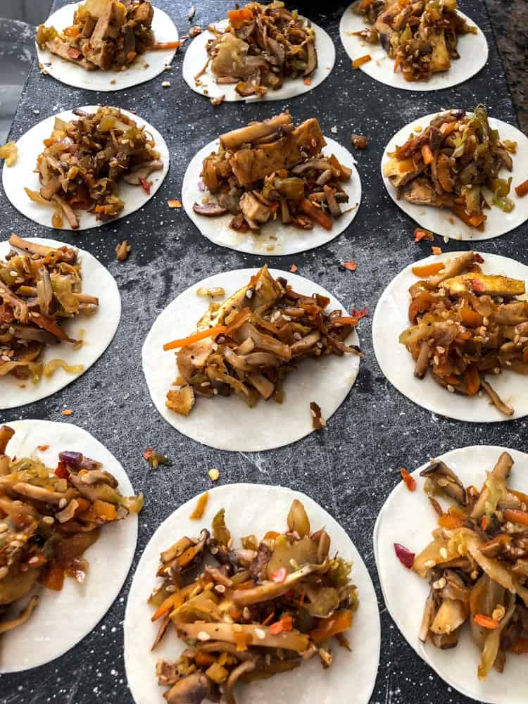 Vegan potstickers/dumplings being filled with vegetables.