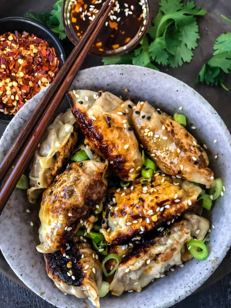 Vegan potstickers/dumplings in a bowl with dipping sauce.