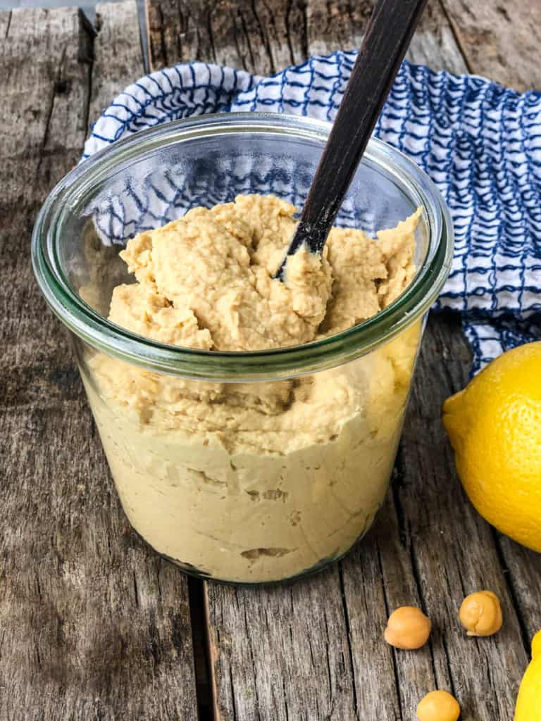 creamy hummus in a jar with a spoon