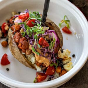 stuffed baked potato with beans, tomato, vegetables and cashew cream