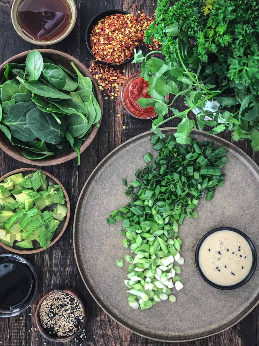 Ingredients for savoury green onion and spinach pancakes on a cutting board.