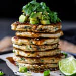 Big Stack of green onion pancakes topped with avocado and onions.