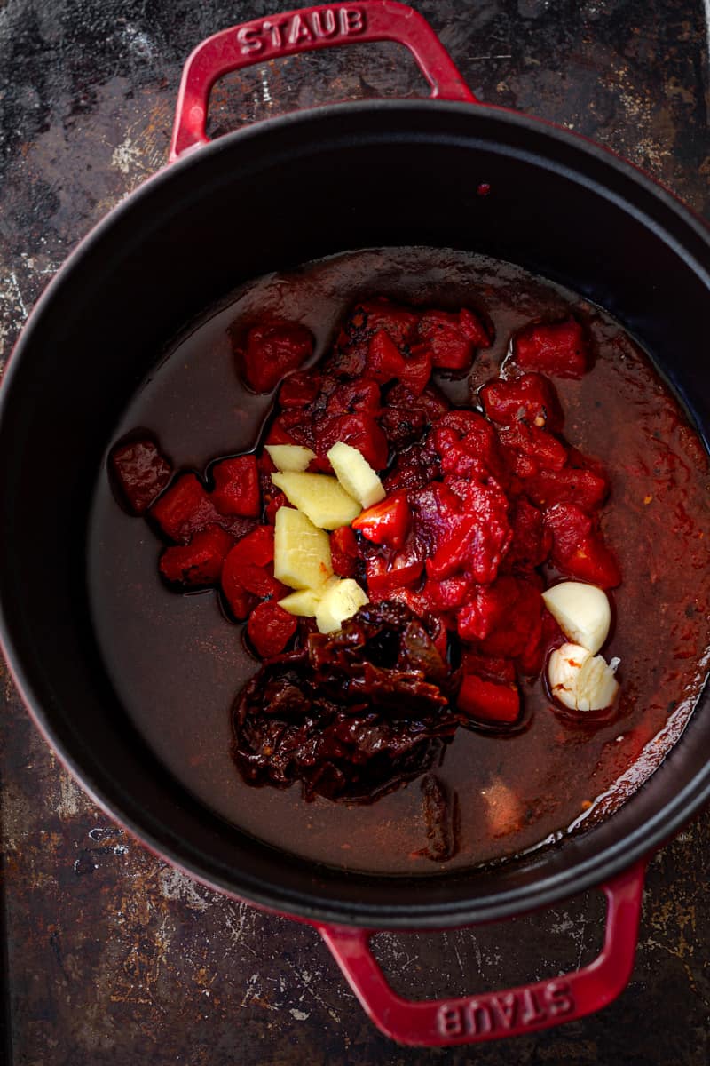 Spicy sauce in a red pot being cooked for jackfruit tacos.