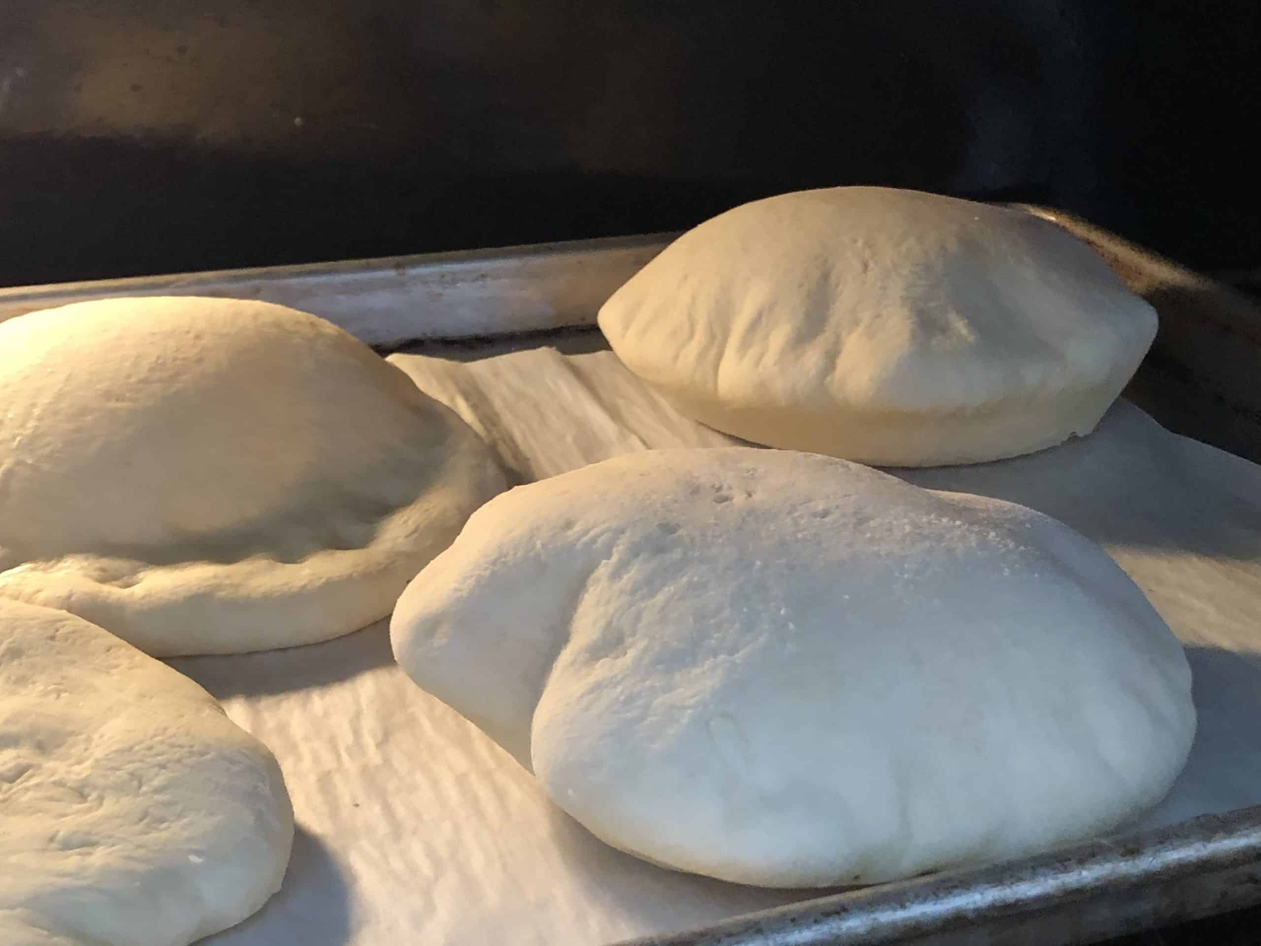 Puffed up pita pockets baking in the oven.