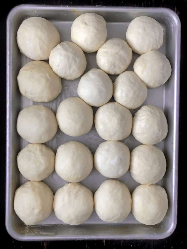 Vegan bread dough balls on a baking sheet. 
