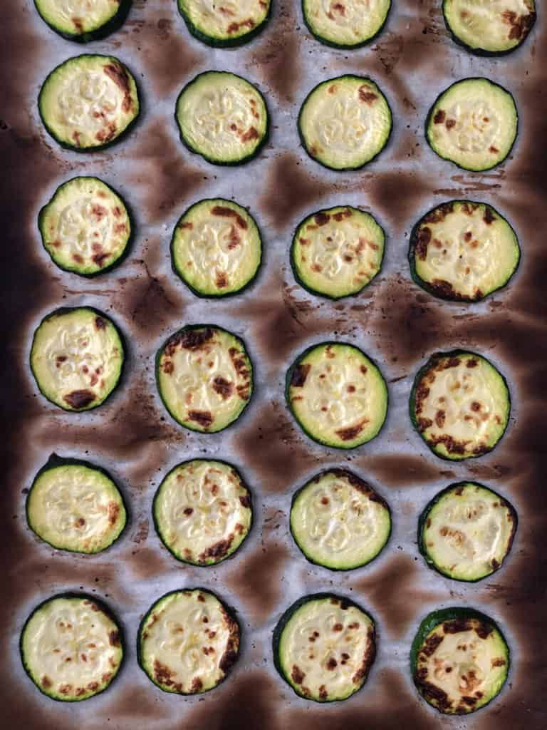 Baking sheet of grilled zucchini slices for vegan lasagna.