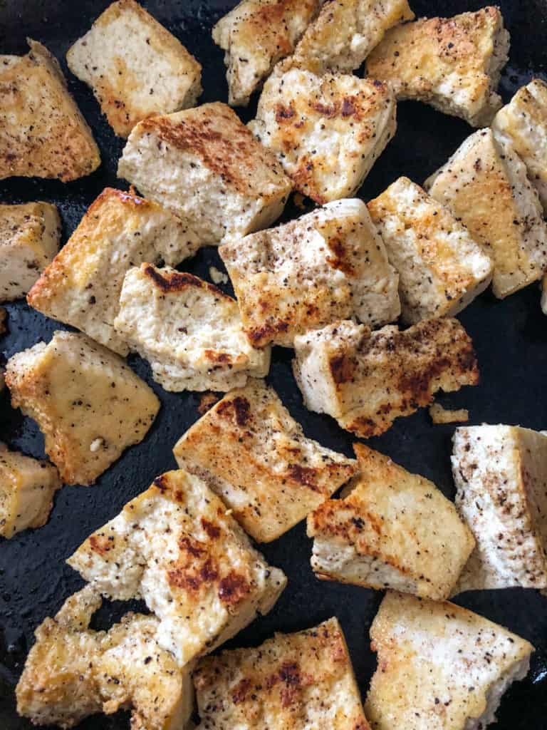 Pan fried chicken tofu chunks in a skillet.