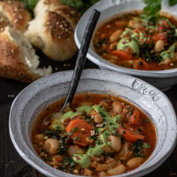 Two bowls of vegan vegetable bean soup with bun.