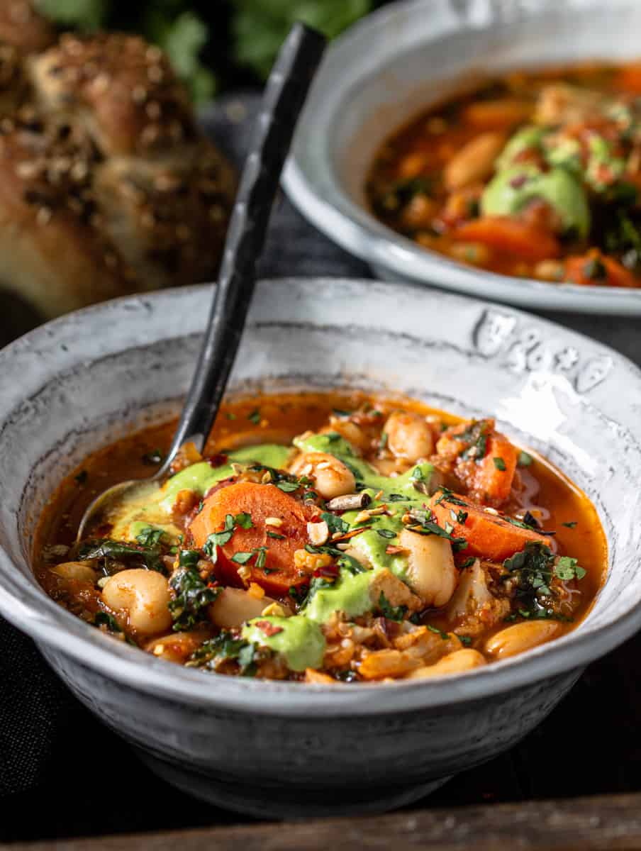 Bowl of vegetable bean soup with homemade buns.