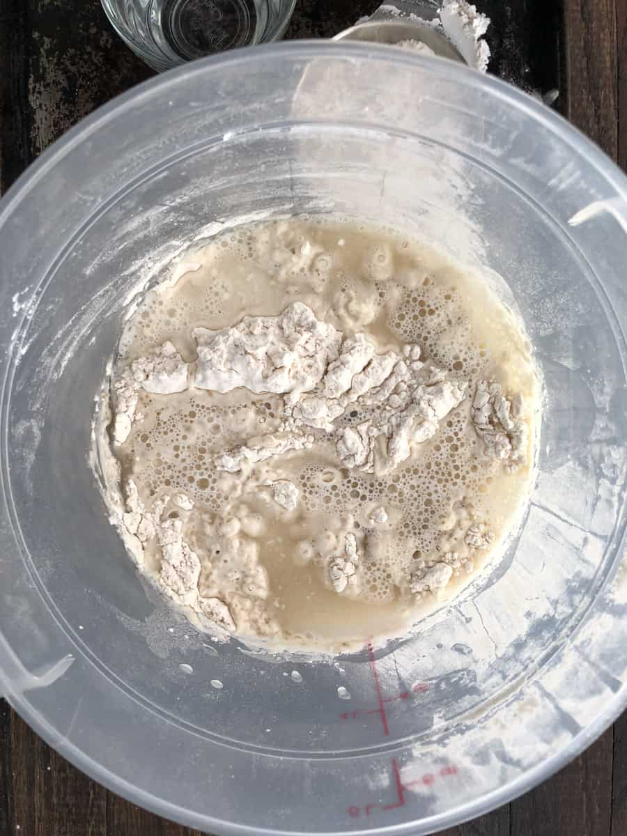 Top view of bread dough in a bucket.