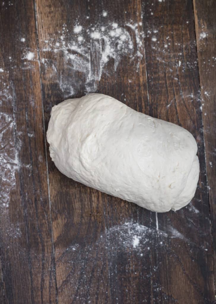 Bread dough being folded into a loaf.