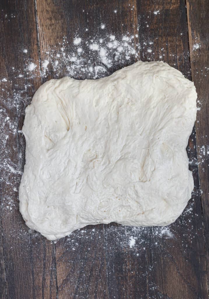 Bread dough being folded into a loaf.