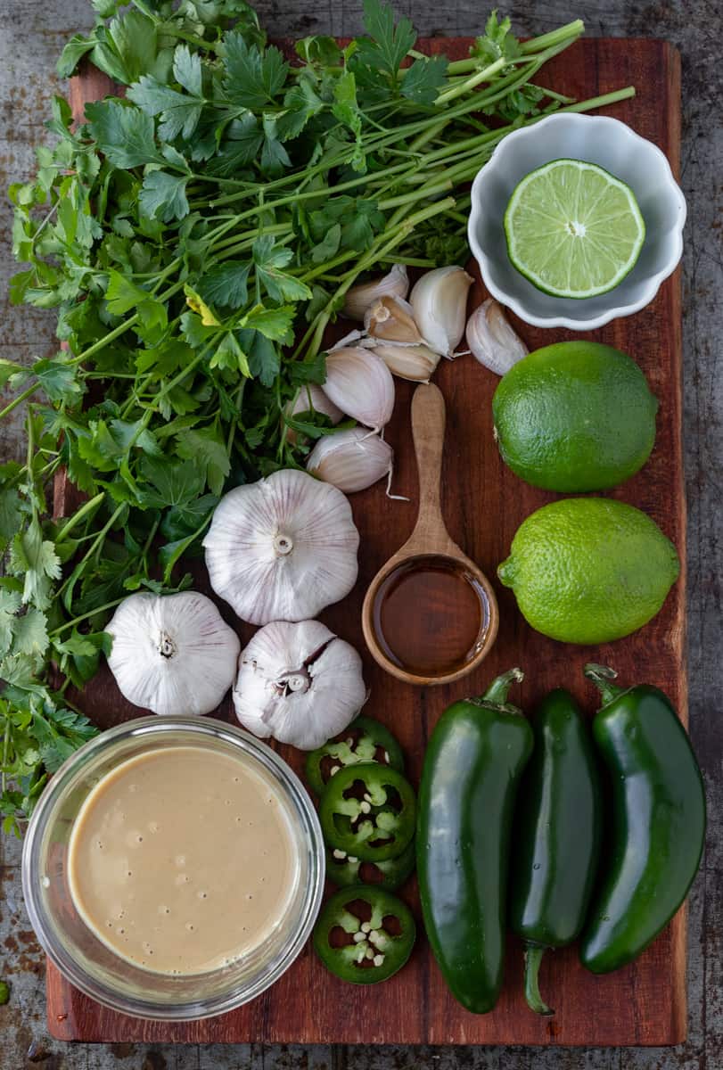 Ingredients for spicy green tahini sauce displayed on a tray.