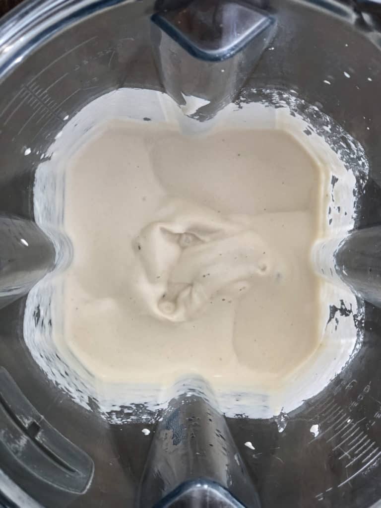 Close up of a blender of cashew cream sauce.