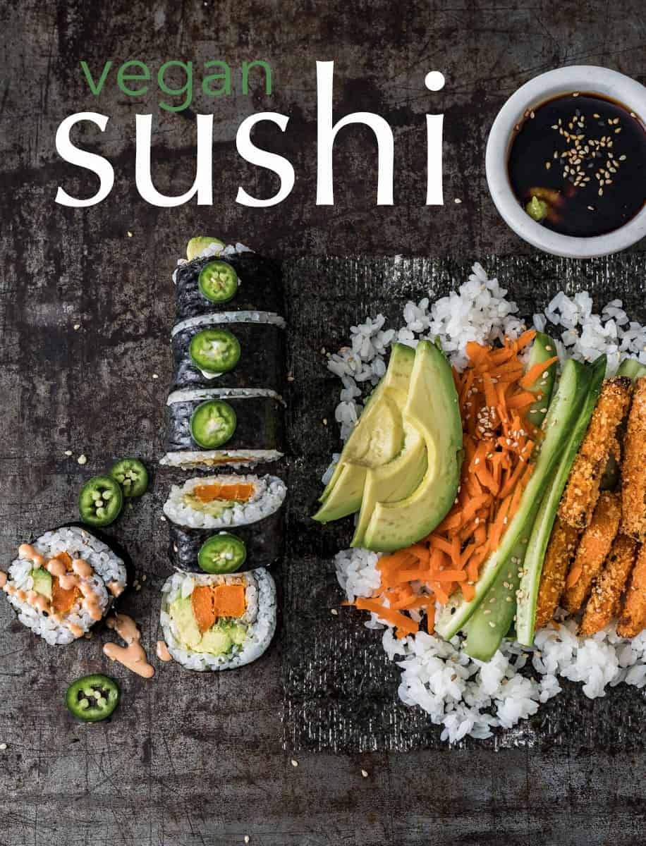 Sushi roll and rice piled high with vegetables on a serving board.