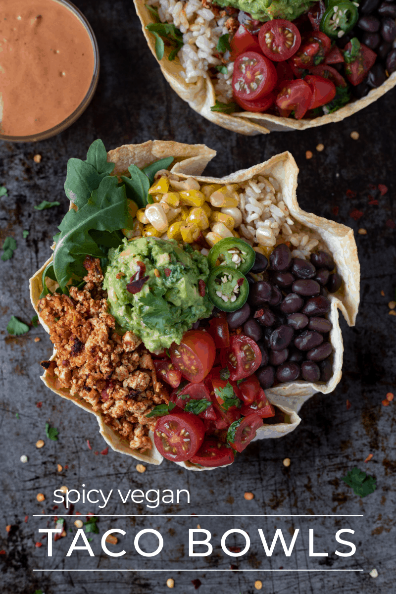 Vegan tofu taco bowls filled with tofu crumbles, guacamole, tomatoes and beans in a tortilla bowl.