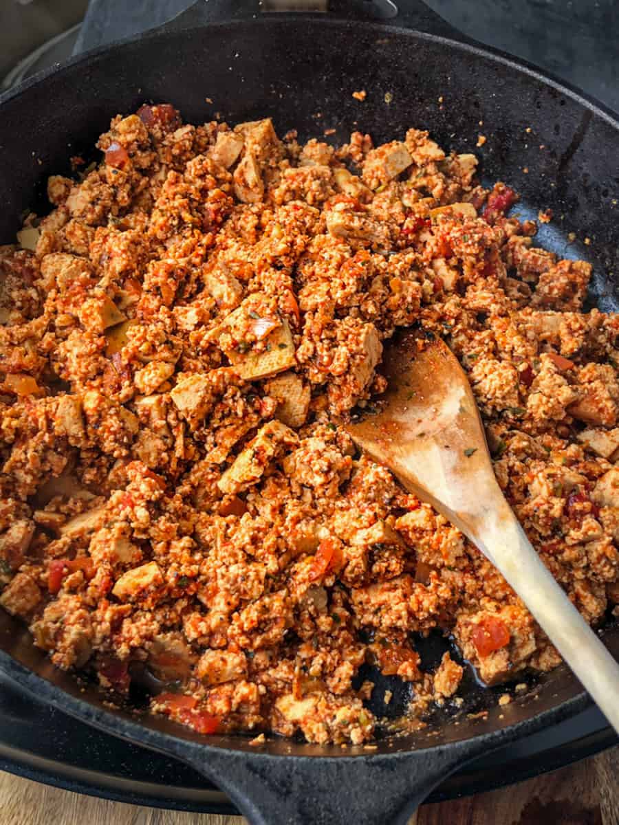 Spiced tofu crumbles in a large skillet.