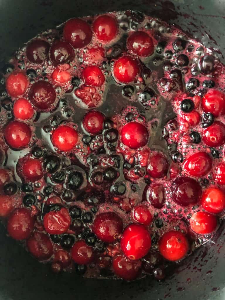 Mixed berries simmering in a saucepan for easy homemade jam.