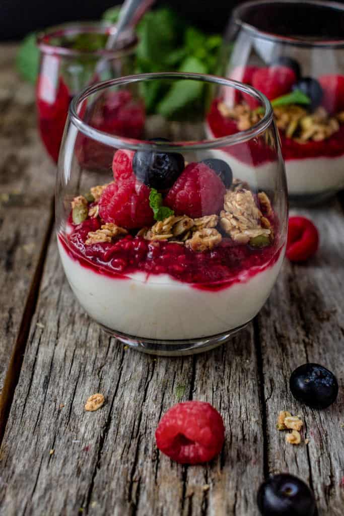 Yogurt and berry compote parfaits topped with fresh berries.