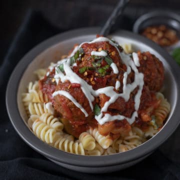 Bowlful of pasta with rose sauce and vegan meatballs.
