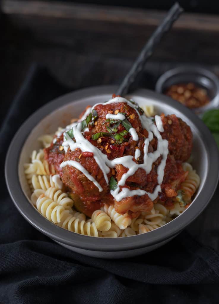 Bowlful of pasta with rose sauce and vegan meatballs.