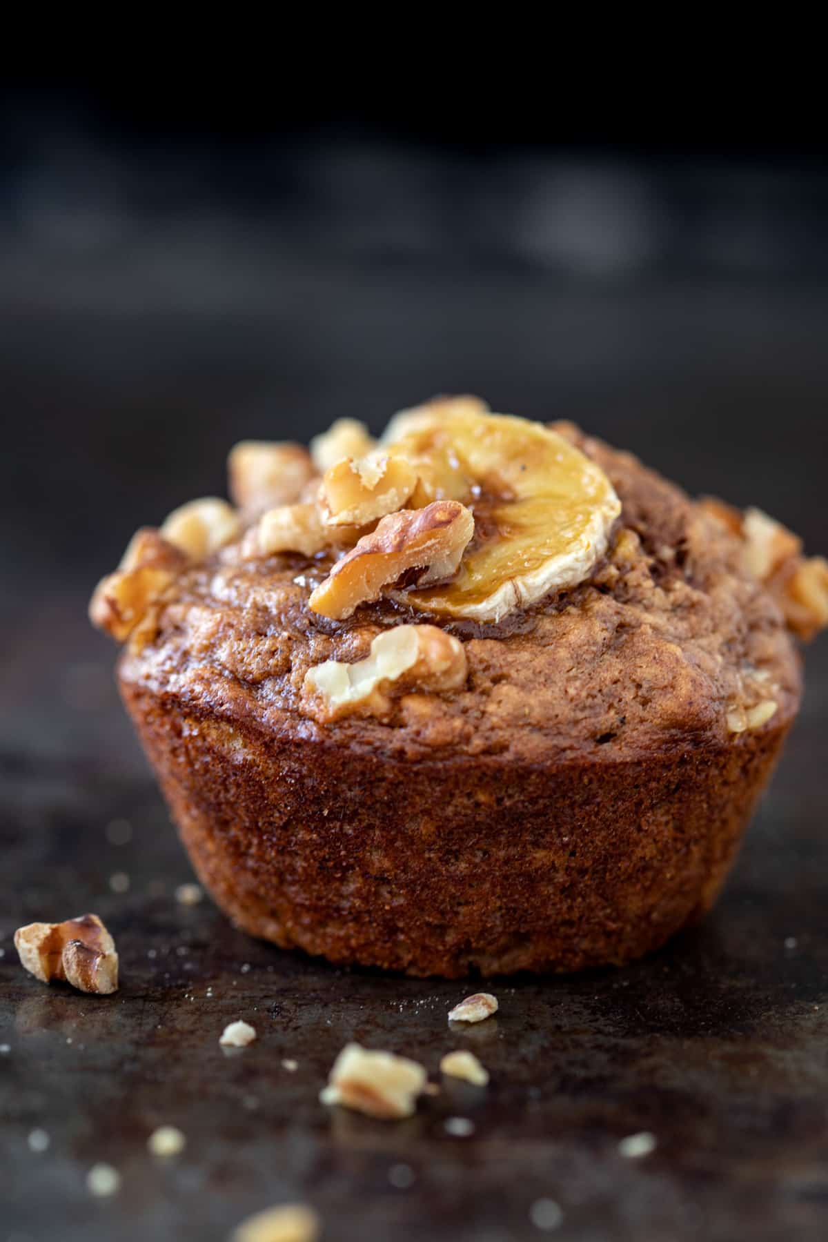 Banana nut muffin topped with salted maple walnuts and a banana slice.