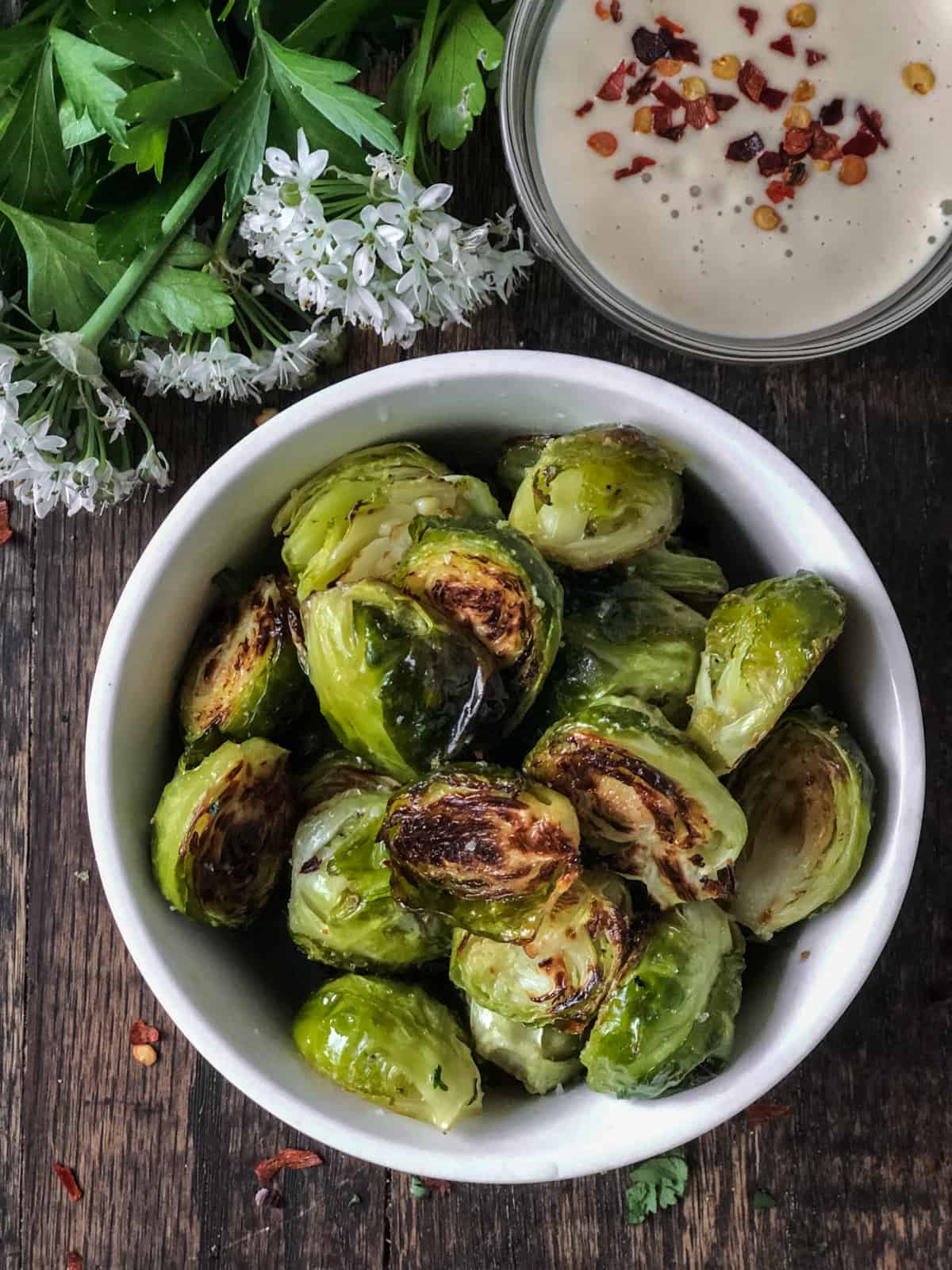 Oven roasted Brussels sprouts in a bowl with sauce.