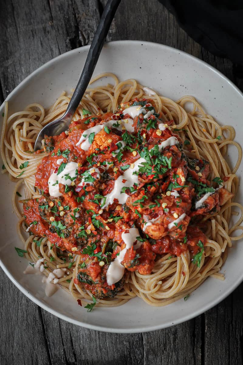 Plateful of spaghetti and creamy rosé sauce with meatballs and veggies.