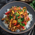Bowl of vegan cashew chicken and vegetables on rice.