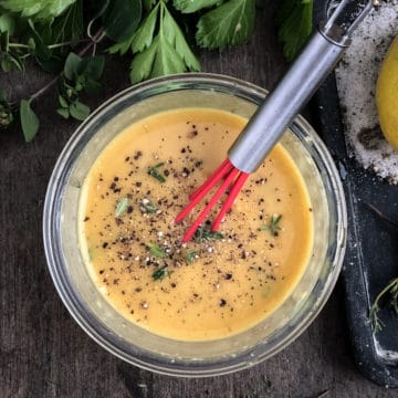 Dish of vegan honey mustard dressing being whisked.