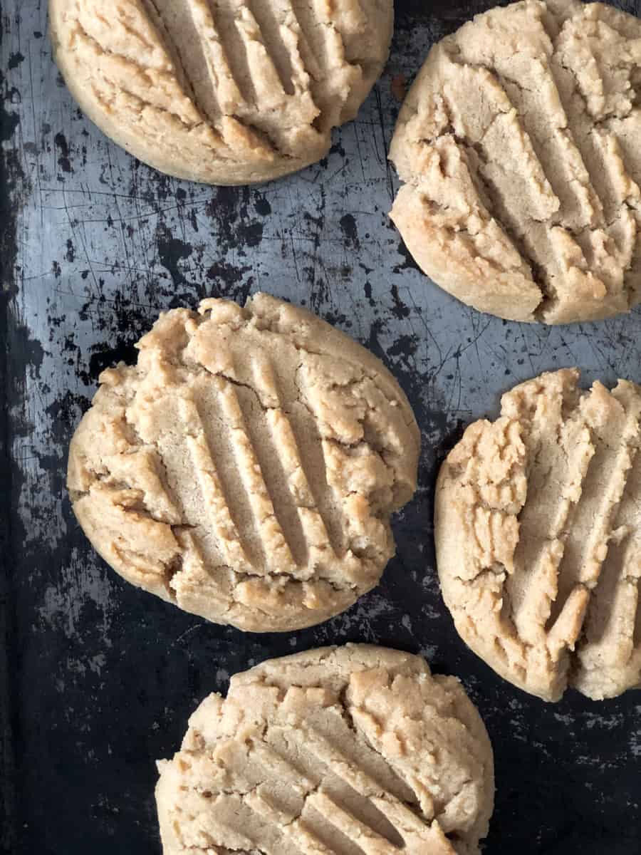 Freshly baked peanut butter cookies on a baking sheet.