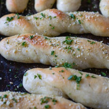 Twisted garlic butter breadsticks with fresh Italian herbs.
