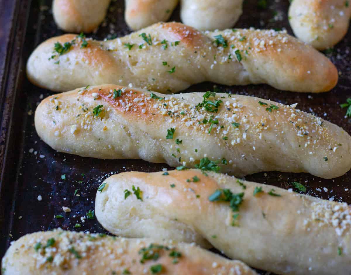 Twisted garlic butter breadsticks with fresh Italian herbs.